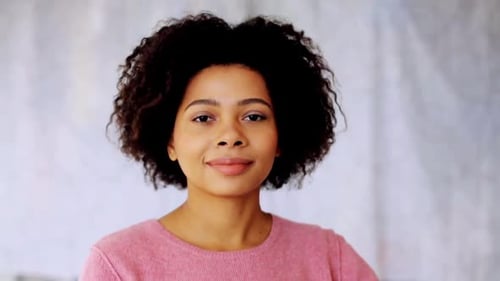 Smiling young woman looking at the camera indoors