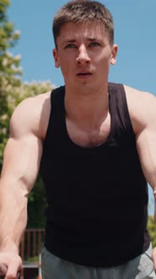 Muscular Man Doing Dips on Parallel Bars Outside