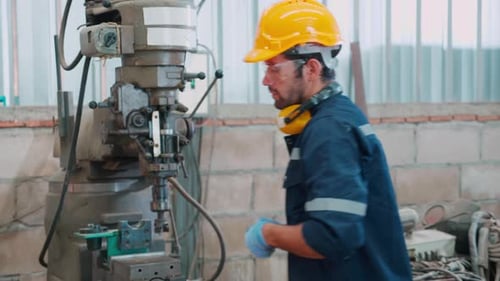 Young caucasian engineer man operating lathe machine for preparing production at factory.