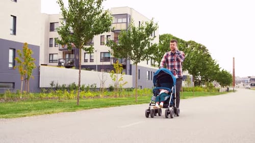 Family, Leisure and People Concept - Father with Little Son in Stroller