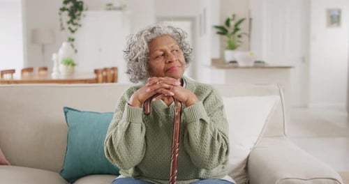 Senior Woman Resting on Couch with Cane