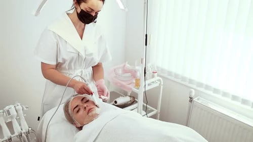 Cosmetologist Beautician Using Ultrasonic Cleansing Tool During Procedure at Cosmetology Studio