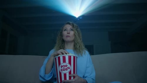 Woman Watches Movie with Popcorn at Home