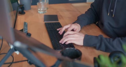 Pessoa digitando no computador dentro do escritório