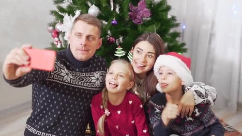 Family Taking Christmas Selfie by Decorated Tree