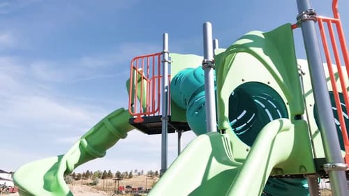 Little Girl Playing on Modern Children Playground in the Suburbs on a Hot Summer Day