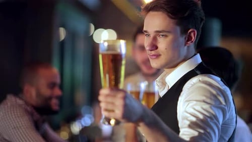 Young Adult Man Holds Up Glass of Beer