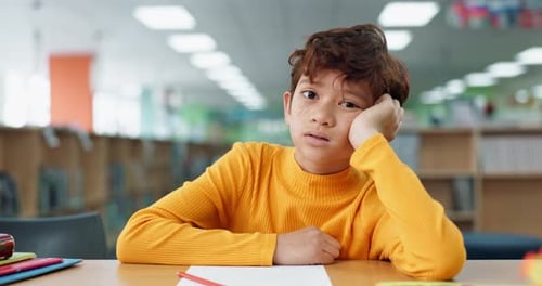 Tired, child and face at school in library for development problem, education and academic fatigue