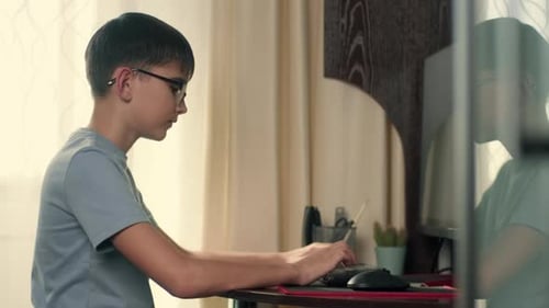 Boy Writes Program Code at Home Using Computer