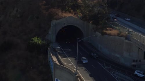 Vue prise par un drone de la circulation de Los Angeles passant sur un pont et sortant d'un tunnel.