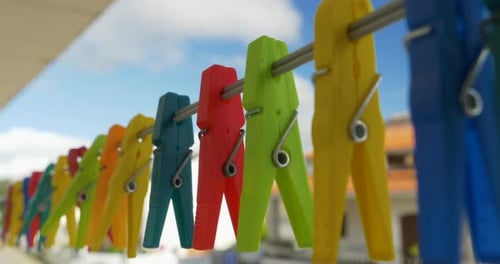 Colorful Clothespins Hanging on Clothesline on Sunny Day