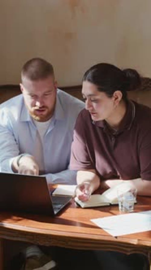 Freelancers Discussing Work by Laptop at Cafe Table, Vertical