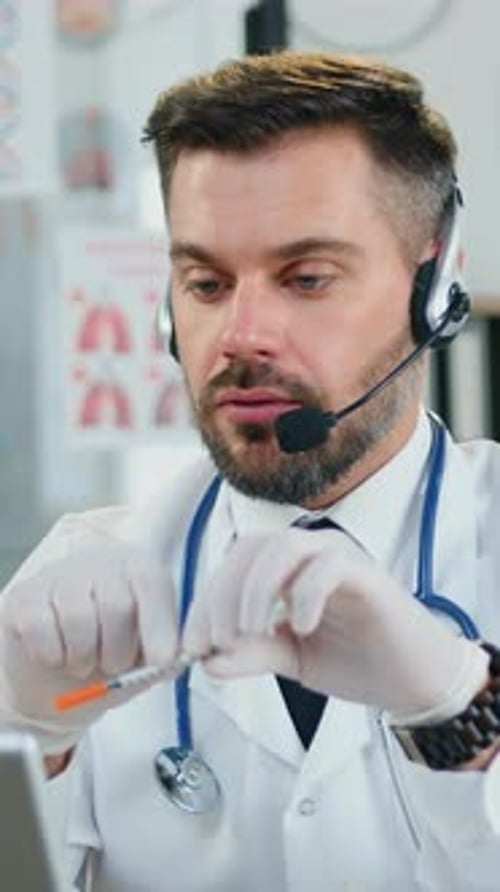 Attractive Smart Man Doctor on White Coat and Protective Latex Gloves Wearing Wireless Headphones