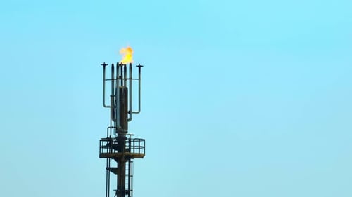 A drone shot of a refinery flare system burning excess gas.
