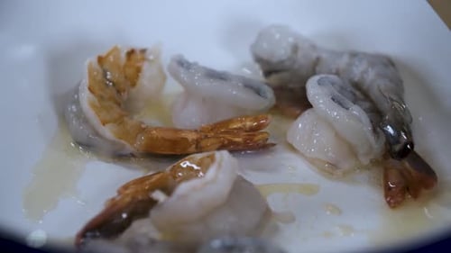 Raw Shrimps Turning Red while Cooking Prawns Frying in a White Pan - Close Up