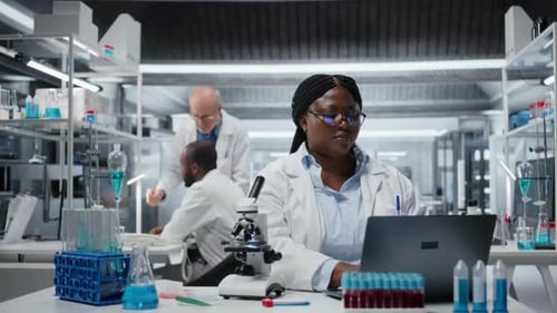 Woman working on laptop in bright laboratory