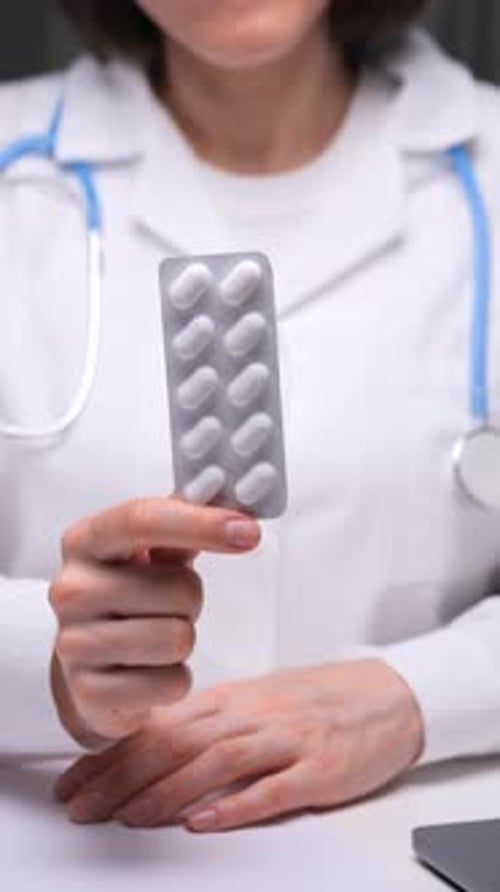 Doctor Holding White Pills Blister Pack