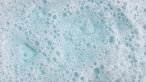 Close Up of Water with Blue Bubbles and Foam