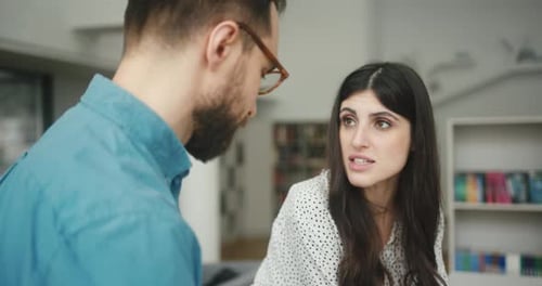 Une équipe préoccupée discute du projet dans la bibliothèque