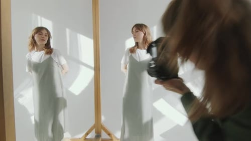 Female Model Posing in front of Mirror during Photo Shoot in Sunlit Studio