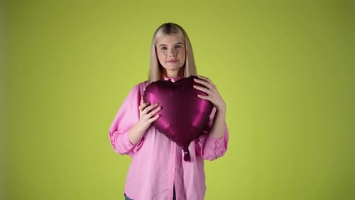 Young Woman Holding Red Heart Shaped Balloon