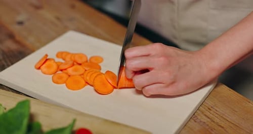 Slicing Carrots on a Wooden Cutting Board