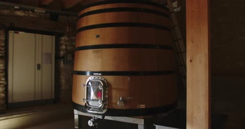 Slow motion shot of a large wooden barrel containing wine at temperature in a factory in Burgos, Spa