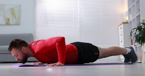 Man doing push ups on fitness mat at home