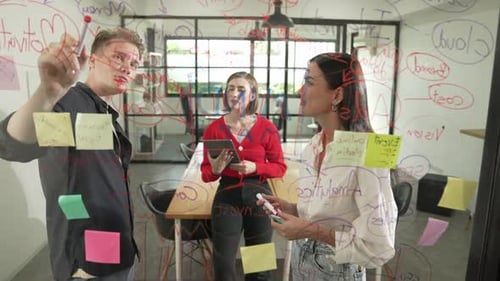 Creative Team Brainstorming Ideas Writing on Glass Whiteboard