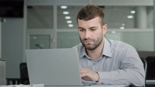 Empresario ejecutivo centrado en serio que trabaja en una computadora portátil comunicándose con un colega Vídeo través