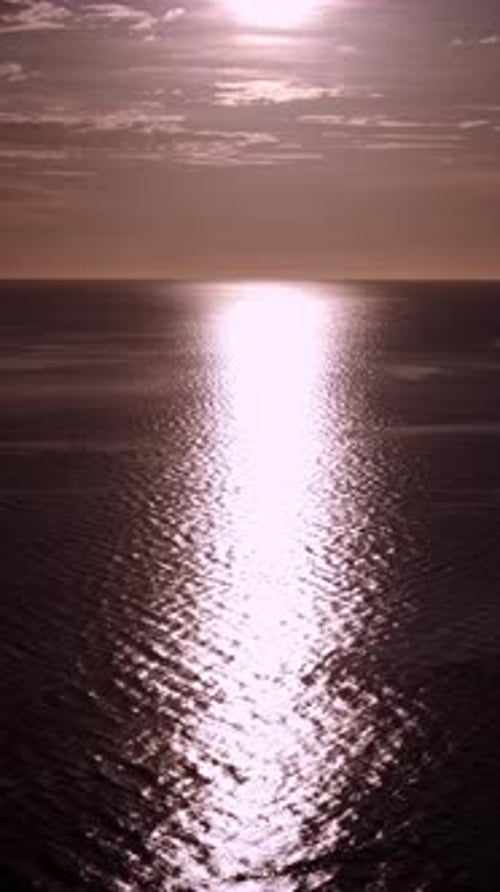Vidéo verticale du soleil de fin d'après-midi au-dessus de l'océan avec de fortes couleurs de coucher de soleil