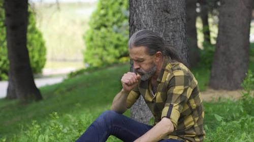 Man coughing outdoors, lung problem.