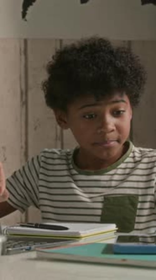 Boy Doing Homework Taking Medicine at Desk