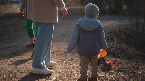 Happy Family Outdoor Back View of Mother and Her Child on Walk in Park Mom Walking Along Road with