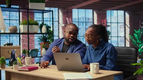 Collaborative Colleagues Working Together at Desk With Laptop
