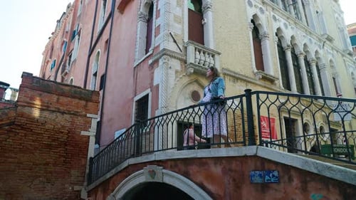 Caucasian Tourist On The Bridge In The Historical Town Of Venice, Italy. Low Angle
