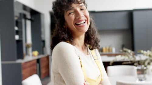 Smiling Woman Poses with Arms Crossed in Kitchen