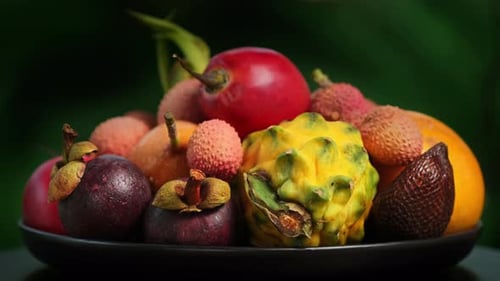 Exotic fruit in the plate rotation. Fresh tropical fruits rotate, close-up. Tropical Fruit