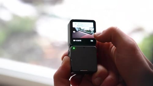 Close Up Hand Adjusts Settings on Pocket Camera