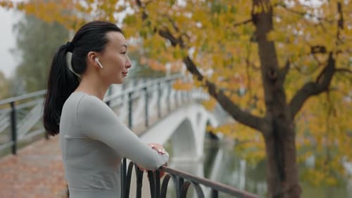 Side View of the Asian Female Runner Enjoying Outside Listening to Music Jogger Woman After Running