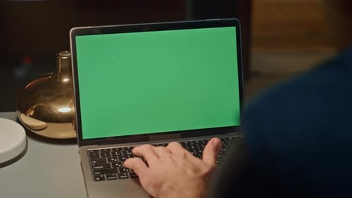 Typing on Laptop with Green Screen at Night