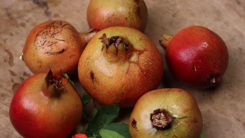 reifer Granatapfel mit Blättern auf einem Holzbrett auf dunklem Hintergrund