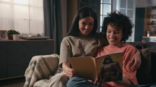 Woman and Child Read Comic Book on Couch
