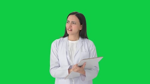 Stressed Indian female scientist taking notes Green screen