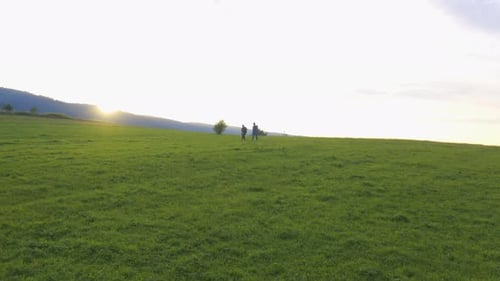 Multiethnic Friends Hiking Couple with Tourist Backpacks Walking on Green Rural Mountain Landscape