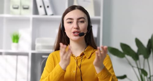 Operador de línea directa sonriente con auriculares hablando en la oficina