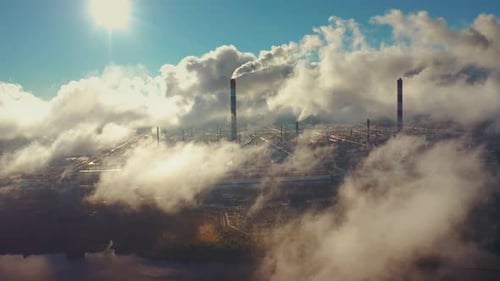 Power plant smokes. Aerial view of the power plant with smoking pipes and clouds passing by