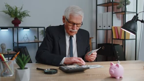 Senior Business Office Man Accountant or Banker Using Calculator Making Money Cash Calculations