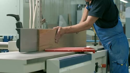 Man Smoothing Lumber with Industrial Planer
