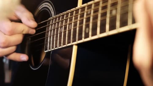 Hands Srumming Chords on a Dark Acoustic Guitar Close Up